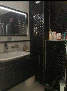 a bathroom with a sink and a mirror at Lovely 2 bedroom condo in Gjilan. in Gjilan