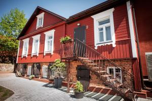 a red house with a staircase in front of it at Lapių Ola in Utena