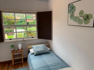 a small bedroom with a bed and a window at La Casita de mi Alma - Das Haus meiner Seele (Tegueste) in Tegueste