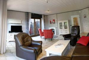 a living room with a couch and chairs and a tv at Haus Münsterland in Nordwalde