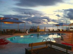 a large swimming pool with a view of the ocean at Alexandras On The Beach and Pool apt in Glyfada