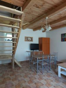 una cucina e una sala da pranzo con tavolo e sedie di Oliva Verde Apartman a Bárdudvarnok