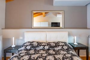a bedroom with a bed with a mirror above it at LORI'S INN 2 in Mondovì