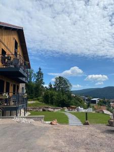 un bâtiment avec un escalier à côté d'une cour herbeuse dans l'établissement La reine appartement pour deux personnes avec magnifique vue et jacuzzi, à Gérardmer