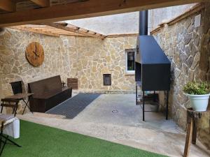 a patio with a tv and a stone wall at Casa rural L´Amparo -3 espigas- Categoría superior-15 personas in Navarrete del Río