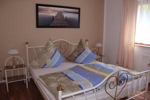 a bedroom with a white bed with blue pillows at Ferienwohnung am Kieferberg in Hormersdorf