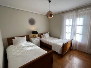 een slaapkamer met 2 bedden naast een raam bij Olazahar in Donamaría