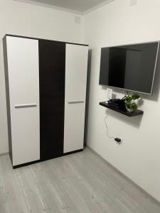 a black and white cabinet with a television on a wall at Patrik Deluxe in Gyula