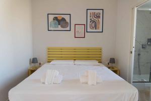 een witte slaapkamer met een groot bed en 2 handdoeken bij Terrazza Giuliana in Rome