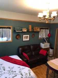 um quarto com uma cama e um sofá de couro em Chez Odette, loft intime em Roberval