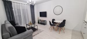 a living room with a couch and a table and chairs at 20 - Apartamenty Siedlce - Nowy apartament przy ul Lewandowskiego in Siedlce