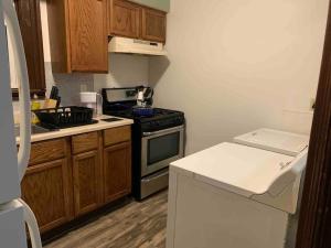 a kitchen with wooden cabinets and a stove top oven at The Navy 2 in Oswego