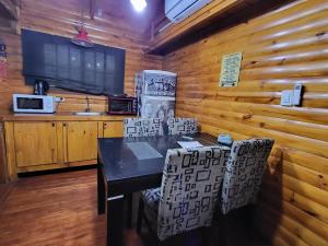 comedor con mesa, sillas y TV en Cabaña Un Lugar en el Mundo Lobos en Lobos