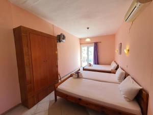 a bedroom with two beds and a window at Studios Kyriaki in Limenaria