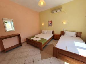 a room with two beds and a window at Studios Kyriaki in Limenaria