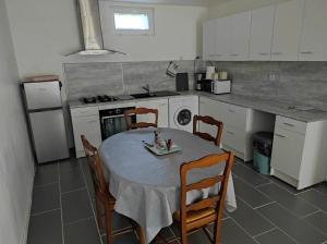 cocina con mesa y sillas en REZ DE CH avec terrasse et parking Appartement 2 ch à Lurs en Lurs