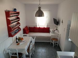 een kleine kamer met een bed en een tafel en stoelen bij Traditional Waterfront House in Mandrakia