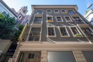 een hoog grijs gebouw met ramen en balkons bij Dorne Suite Taksim Hotel in Istanbul