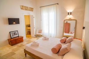 een slaapkamer met een groot bed en een spiegel bij Masseria Il Passo in Favignana