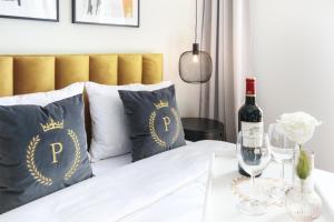 a bed with pillows and a bottle of wine on a table at Apartament Warta Park Poznań - Basen Pool - Sauna - AC Klimatyzacja - Cost Free Parking - Pelikan - 24h check in in Poznań