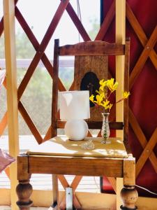 a table with a lamp and flowers on it at Byron Bay Hinterland Eco-Retreat Terracota Yurt in Eureka