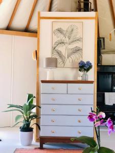 a bedroom with a dresser with a picture on the wall at Byron Bay Hinterland Eco-Retreat Terracota Yurt in Eureka