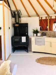 a kitchen with a black stove in a tent at Byron Bay Hinterland Eco-Retreat Terracota Yurt in Eureka