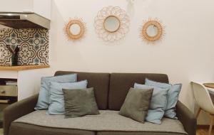 a couch with pillows in a living room with mirrors at Studio La ciotat Les Anges du Vieux Port in La Ciotat