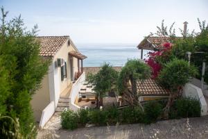 una vista de una casa con el océano en el fondo en Alexandras On The Beach and Pool apt, en Glyfada
