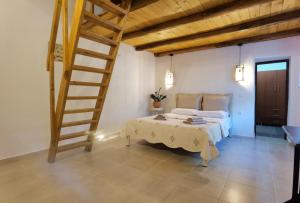 1 dormitorio con cama y escalera de madera en Elaion Thea-Nies, en Soúrpi