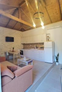 a living room with a couch and a kitchen at Elaion Thea-Nies in Soúrpi
