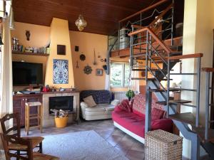 a living room with a red couch and a spiral staircase at Il tuo angolo di paradiso in Monreale
