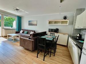 a kitchen and a living room with a table at Closer to the Sea Apartments in Kołobrzeg
