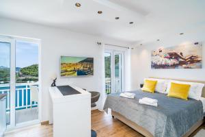 a white bedroom with a bed and a balcony at Villa Ivanka in Zaton