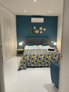 ein Schlafzimmer mit einem großen Bett mit blauer Wand in der Unterkunft Marina Luxury Apartments in Ischia