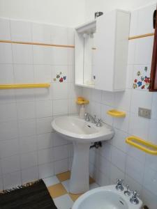 a white bathroom with a sink and a mirror at Dimora Damare in Caronia Marina +20 photos