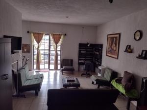 a living room with a couch and chairs and a window at Loft aeropuerto in Guatemala