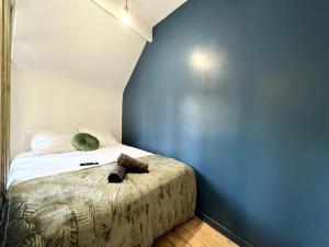 Cama en habitación con pared azul en *Le cocon de Montigny*, en Montigny-sur-Loing
