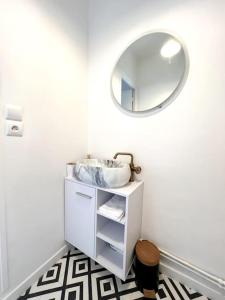 y baño con lavabo y espejo. en *Le cocon de Montigny*, en Montigny-sur-Loing