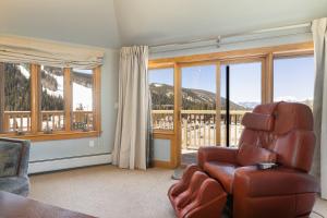 - un salon avec une chaise et de grandes fenêtres dans l'établissement 2300 Red Hawk Lodge condo, à Keystone