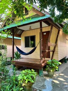 a hammock in front of a small house at Sandee Bungalow in Thong Nai Pan Noi