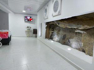 een kamer met een stenen muur en een open haard bij La Casa de La Piedra in Guatapé