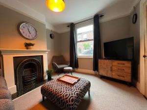 a living room with a fireplace and a tv at Charming 3 bedroom property in Bury St Edmunds in Bury Saint Edmunds