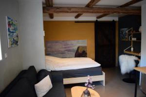 1 dormitorio con cama, sofá y mesa en The Sybilla Apartment - cosy and modern basement apartment, en Klaksvík