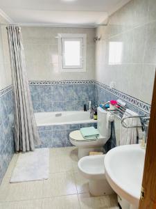 a bathroom with a toilet and a tub and a sink at Casa Azure in Gran Alacant