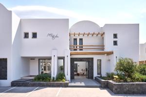 a white house with a courtyard at Alleys All-Suite Hotel & Spa in Pirgos