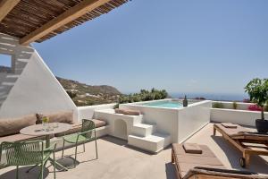 a patio with a table and chairs and a swimming pool at Alleys All-Suite Hotel & Spa in Pirgos