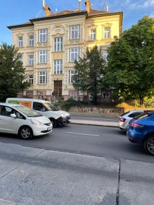 a street with cars parked in front of a building at Budapest Gellért Apartman in Budapest