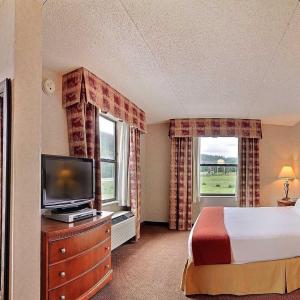 um quarto de hotel com uma cama e uma televisão em Ruidoso Mountain Inn em Ruidoso