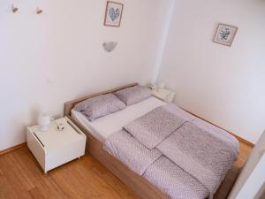 a small bedroom with a bed and a night stand at D&N Apartment in Ljubljana
